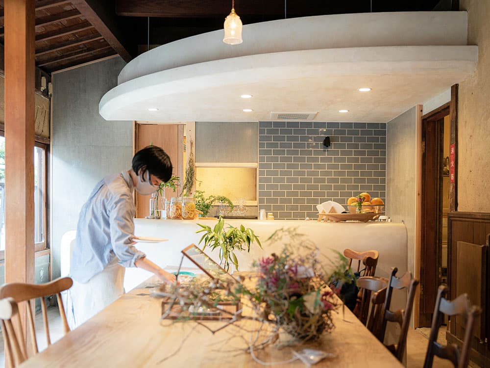 A staff member working at the cafe counter under a curved dropped ceiling